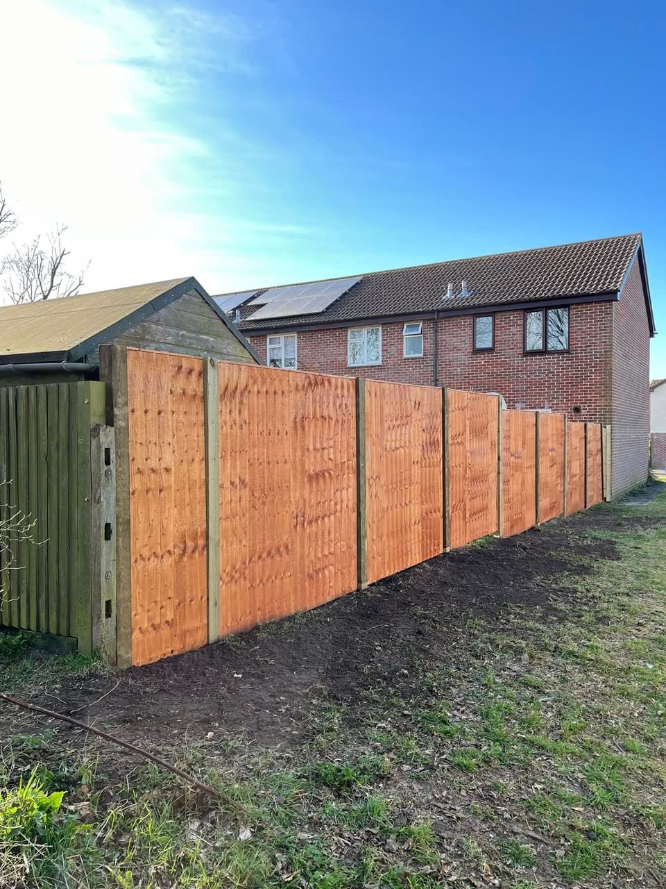 Close-board timber fencing with concrete posts